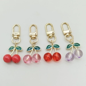 Colorful acrylic cherry keychains with gold clasps and green leaves in four vibrant colors