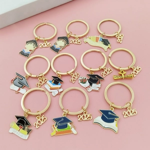 Détail des porte-clés de remise des diplômes 2025 avec chapeaux et livres en émail