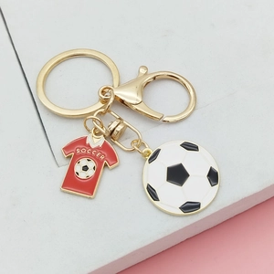 Détail d'un porte-clés football doré avec breloque maillot rouge et ballon classique