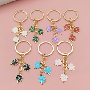 Detail showing colorful alloy clover pendants on golden keychains in multiple vibrant hues