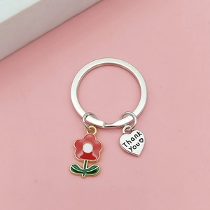 Detail of floral enamel charm and Thank You engraved heart pendant on keychain