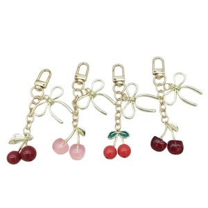 Lot de quatre porte-clés cerise avec nœuds en rouge et rose pour sacs à main