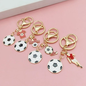 Détail macro de porte-clés football avec pendentifs maillot et chaussure en métal doré