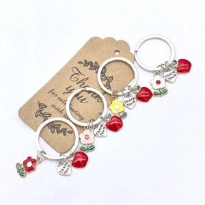 Détail de porte-clés pomme et fleurs avec charmes en cœur Thank You sur étiquettes