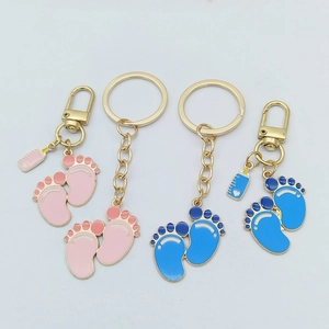 Detail of cute baby footprints and milk bottle pendants on gold alloy keychains