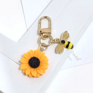 Porte-clés exquis tournesol et abeille avec fermoir en métal doré sur fond blanc
