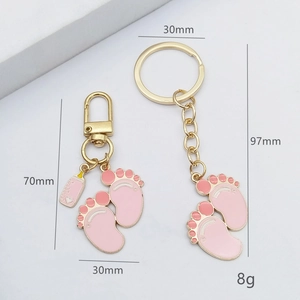 Pink and gold baby-themed keychain set with feet and bottle charms for accessories