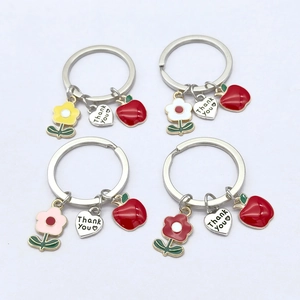 Détail des pendentifs cœur Thank You et des porte-clés fleurs en émail coloré