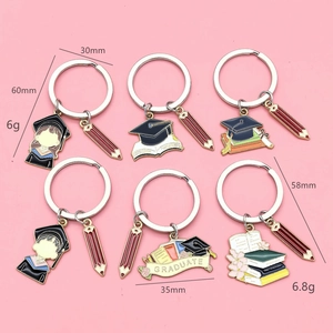 Detail view of graduation keychains with colorful enamel student icons and red pencil charms