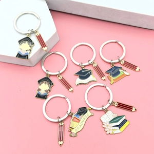 Detailed view of graduation metal keychains featuring student figures and scrolls