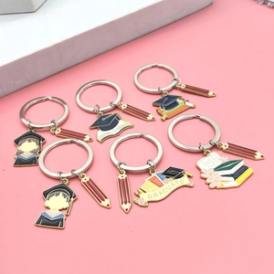 Graduation gift keychain set with diploma books and graduation cap charms on stands