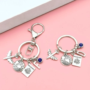 Travel-themed keychain with airplane, globe, passport and custom initial pendants