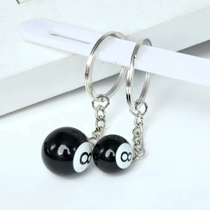 Detailed view of glossy black resin number 8 pool ball keychains with silver metal rings