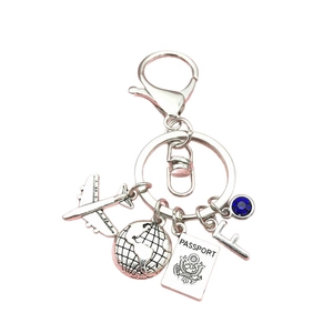 Travel keychain with airplane, globe, passport and blue crystal on silver metal ring