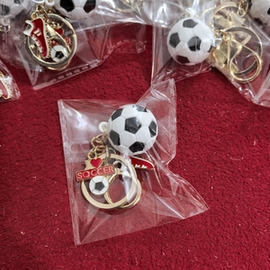 Macro detail of 3D PVC soccer keychain set with football charm and golden ring clasp