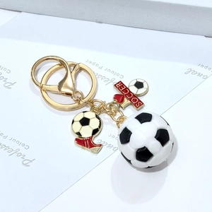 Detail of 3D PVC soccer keychain with gold metal ring, red shoe charm, and SOCCER tag