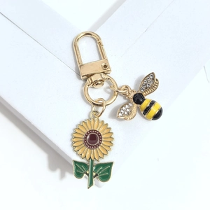 Vue détaillée du porte-clés tournesol et abeille avec émail jaune et pierres brillantes