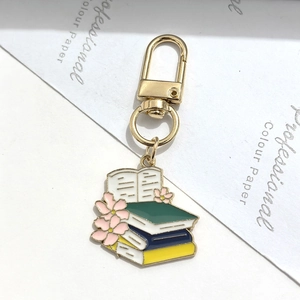 Portachiavi laurea in lega dorata con libri in smalto e fiori di ciliegio rosa