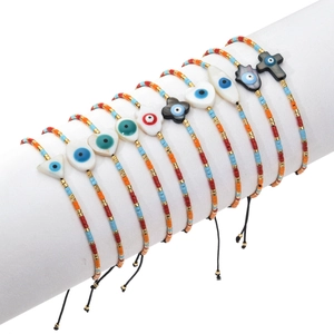 Detail view of 10 bohemian beaded bracelets with colorful Miyuki beads and shell evil eye charms