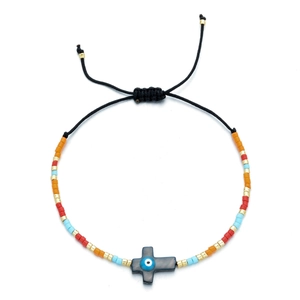 Bohemian Miyuki beaded bracelet with colorful shell cross and evil eye charm on adjustable cord