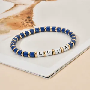Detailansicht eines handgefertigten LOVE-Armbands mit blauen Perlen und goldenen Akzenten