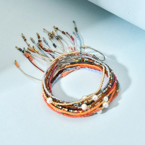 Detalle de las pulseras multicapa de cuentas Miyuki con perlas y cordones trenzados ajustables
