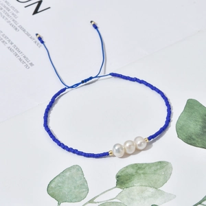 Detail showing deep blue beads with freshwater pearls and adjustable braided rope closure