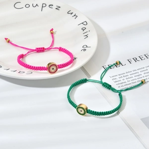 Détail de bracelets en corde tissée à la main avec breloques œil bleu en rose et vert