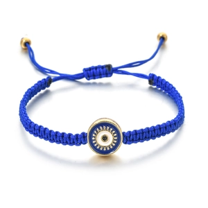 Détail du bracelet tressé œil bleu avec nœud coulissant et perles dorées fines