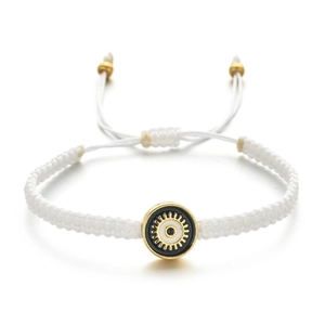 Détail d'un bracelet en corde tressée blanche avec pendentif œil maléfique doré chic
