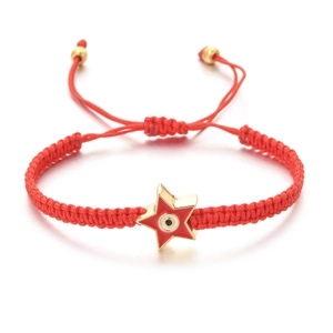 Detail of red woven cord bracelet featuring a gold star charm with an evil eye emblem