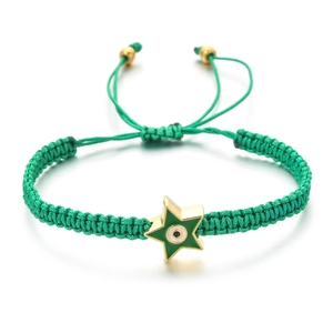 Macro detail of a green woven bracelet featuring a gold star pendant with a devil's eye