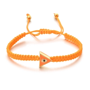 Macro detail of hand-woven orange cord bracelet with evil eye gold triangle charm