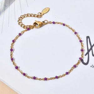 Detail of gold stainless steel chain bracelet with purple enamel beads and lobster clasp