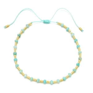Close-up of handmade blue beaded bracelet with gold spacers and adjustable silk cord