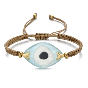 Close-up of a woven evil eye bracelet with blue resin bead and adjustable cord details