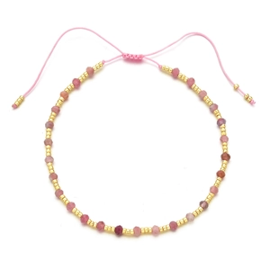 Detail of pink natural stone beaded bracelet with adjustable cord and golden spacers