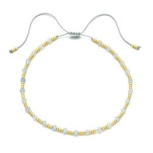 Minimalist handmade beaded bracelet with blue faceted stones and gold beads on gray cord