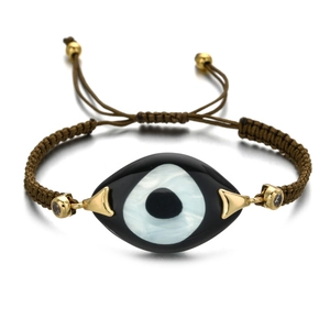 Detailed close-up of handmade woven evil eye bracelet with gold accents and zircon stones