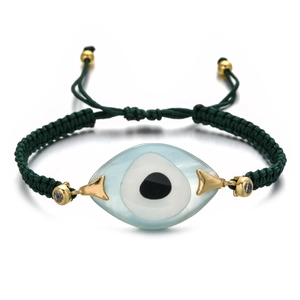 Macro view of woven evil eye bracelet with light blue resin charm and gold-plated accents