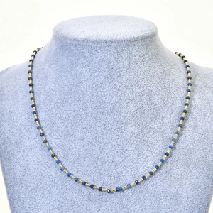 Detail of faceted blue natural stone beads and gold metal spacers on a jewelry necklace