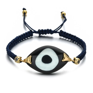 Macro view of woven evil eye bracelet with blue cord and crystal gold-plated beads