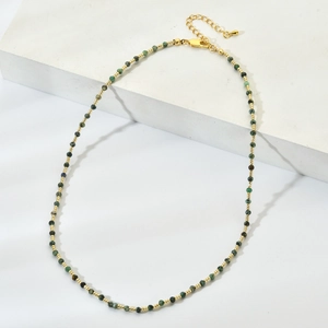Detail of green natural stone beaded necklace with gold spacers and lobster clasp