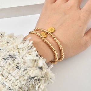Gouden roestvrijstalen kralenarmband set met gepersonaliseerde letterbedeltjes K en C