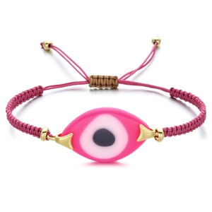 Close-up of pink woven Evil Eye bracelet with adjustable gold slider and resin charm