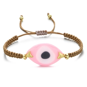 Detailed view of pink Evil Eye pendant on a brown braided adjustable Greek bracelet