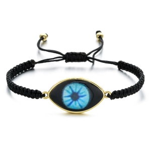 Detailed view of woven black Evil Eye bracelet with adjustable cord and gold metal charm
