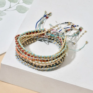 Bohemian multicolored seed bead bracelet set with adjustable drawstring on white stone