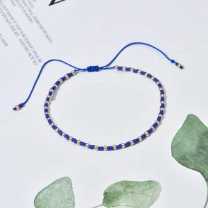 Detail of bohemian handmade beaded bracelet featuring navy blue beads and gold accents
