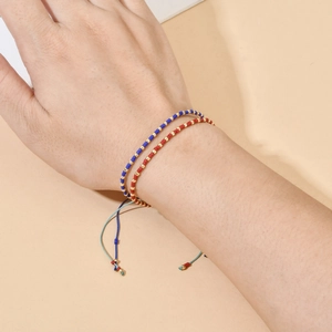 Detail of bohemian handmade beaded bracelets with adjustable woven cord and gold accents